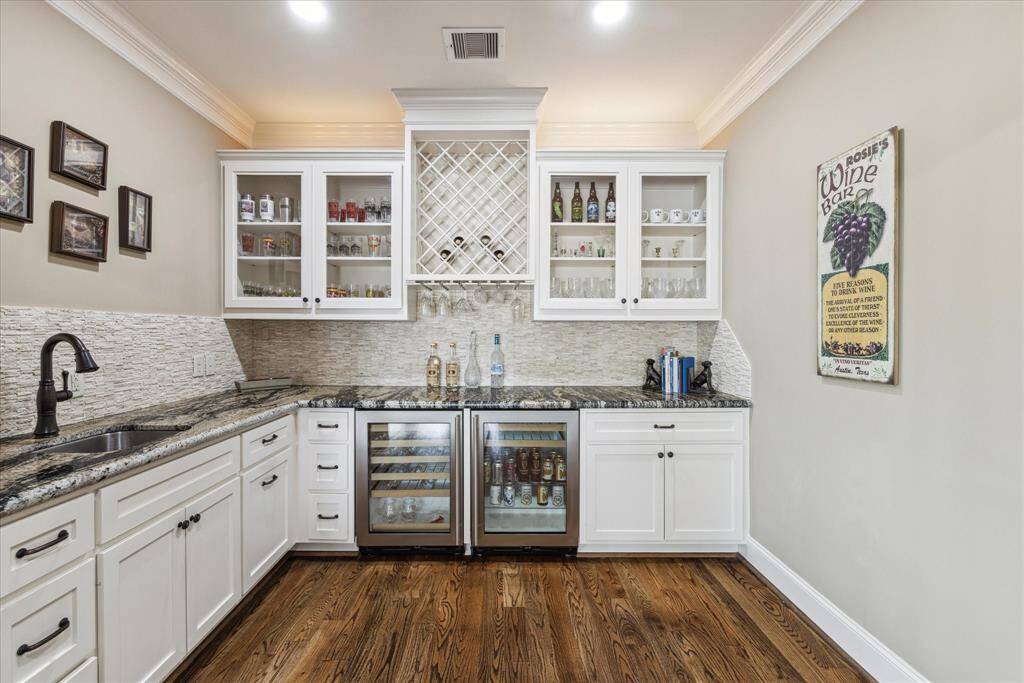 Oversized wet bar with beverage and wine cooler and ample cabinet, counter space.