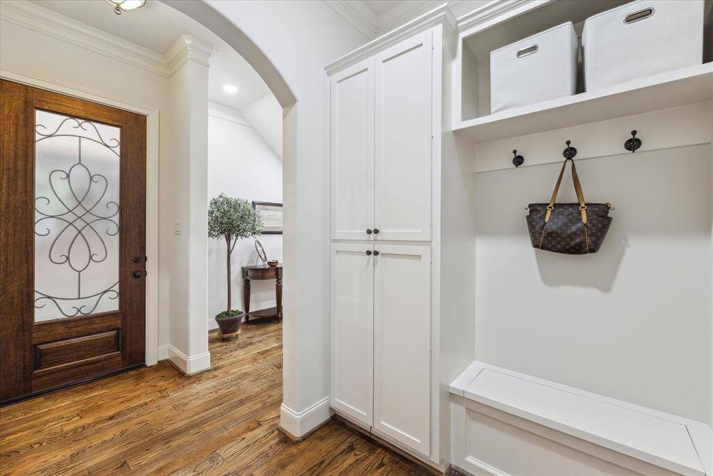 Drop zone area with custom cabinets, hooks, and a bench, conveniently located right by the entrance.