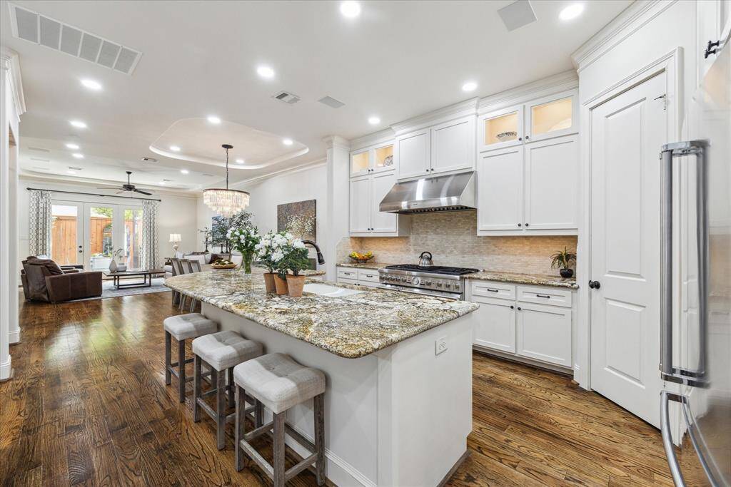 Kitchen features bar seating, six burner gas stove, double ovens and more.