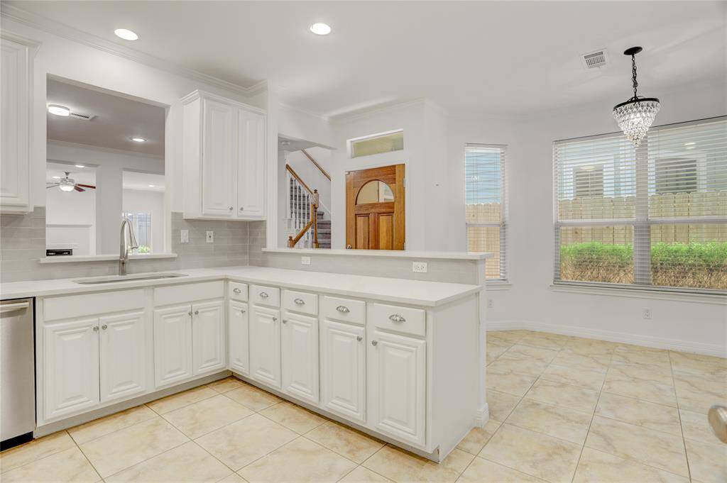 Another angle from the kitchen shows the layout and the breakfast nook area with great natural light and views of the front door. The open layout makes it easy to move between spaces, ideal for everyday living.