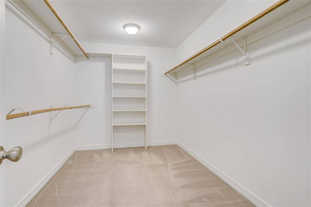 The primary closet is conveniently located within the ensuite bathroom and offers generous space for storage. With built-in shelving and multiple hanging rods, there’s plenty of room to keep everything organized and within easy reach.