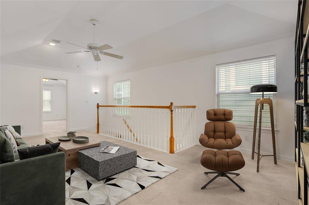 Here’s another view of the upstairs landing, showcasing just how much space this area offers. With natural light streaming in from both windows and overhead lighting above, the space feels bright and open. Whether you're creating a second living area, a quiet home office, or a fun playroom, this flexible layout adapts to your needs. This photo is virtually staged.