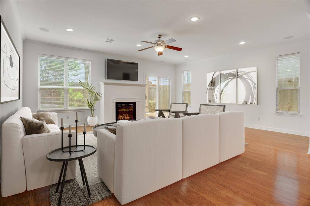 A closer look at the living room, where the chimney serves as a striking focal point. This space is enhanced by a built-in surround sound system, perfect for immersive movie nights or entertaining guests. Sliding glass doors open to the backyard patio with a gazebo, setting the scene for memorable gatherings. This photo is virtually staged.