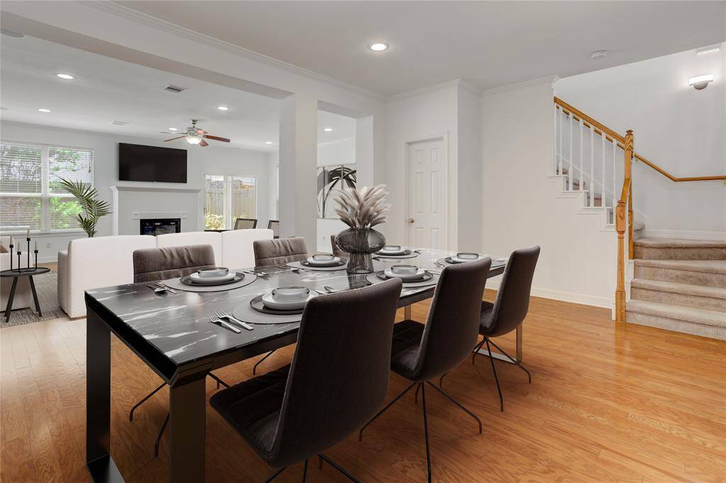 From the dining area, take in the expansive open layout that effortlessly flows into the living space. The staircase to the right adds a touch of charm and leads to the private living quarters above. This open-concept design makes entertaining and everyday living both stylish and functional. This photo is virtually staged.