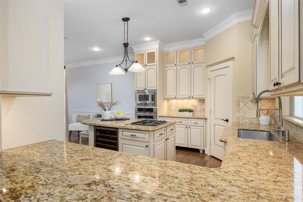 Rich cabinets with updated hardware provide a clean and timeless look, enhancing the sense of brightness and openness in the space.