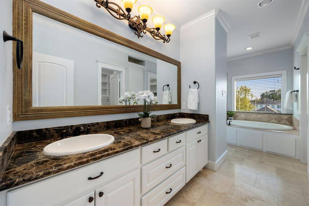 The primary bath offers dual vanities with plenty of storage. There is so much space to get ready here.