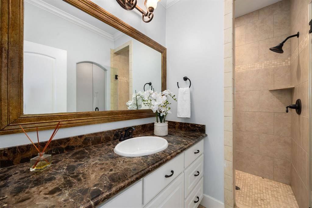 The ensuite bath features a large vanity and oversized walk-in shower with beautiful tile work and glass front.