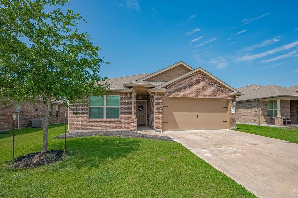 Charming brick home with a two-car garage, neatly manicured lawn, and a welcoming front porch. Ideal for a cozy family living.