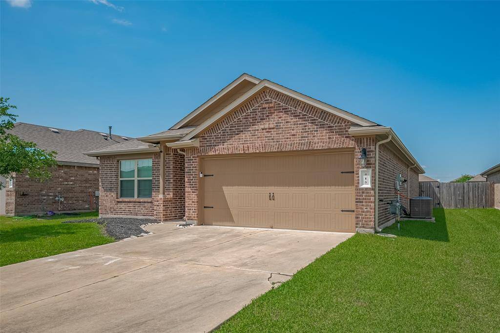 This is a charming, single-story brick home with a two-car garage. It features a well-maintained front lawn and a spacious driveway, perfect for a family looking for a cozy and inviting space.
