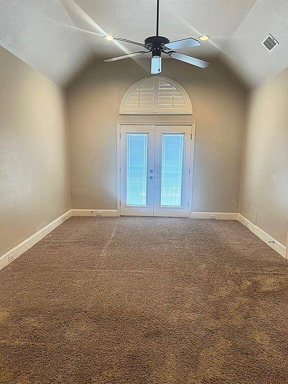Huge primary bedroom with high ceilings and ceiling fan