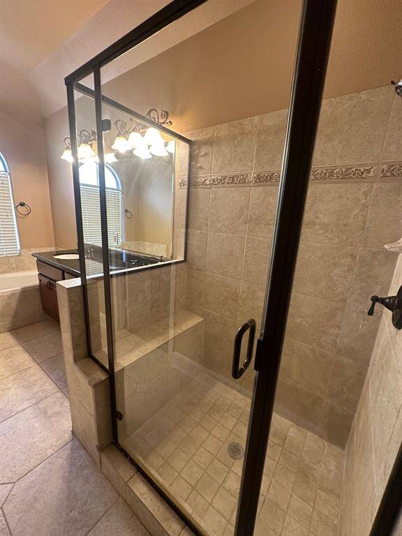 Beautiful tiled separate shower with bench seating in primary bath