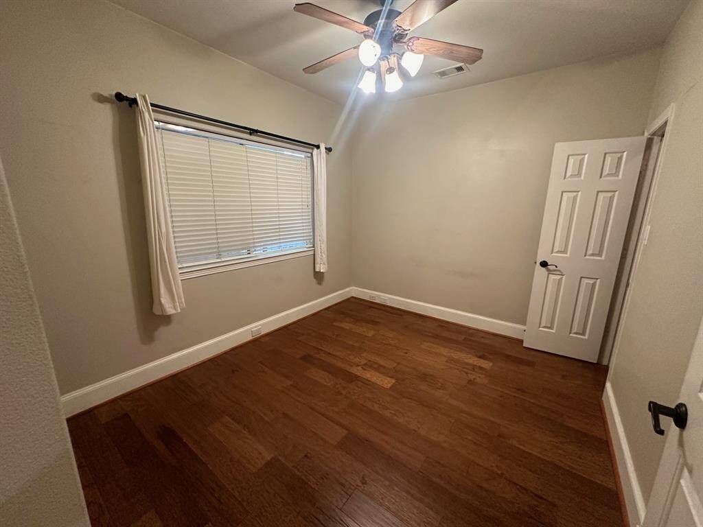 Secondary bedroom with wood flooring