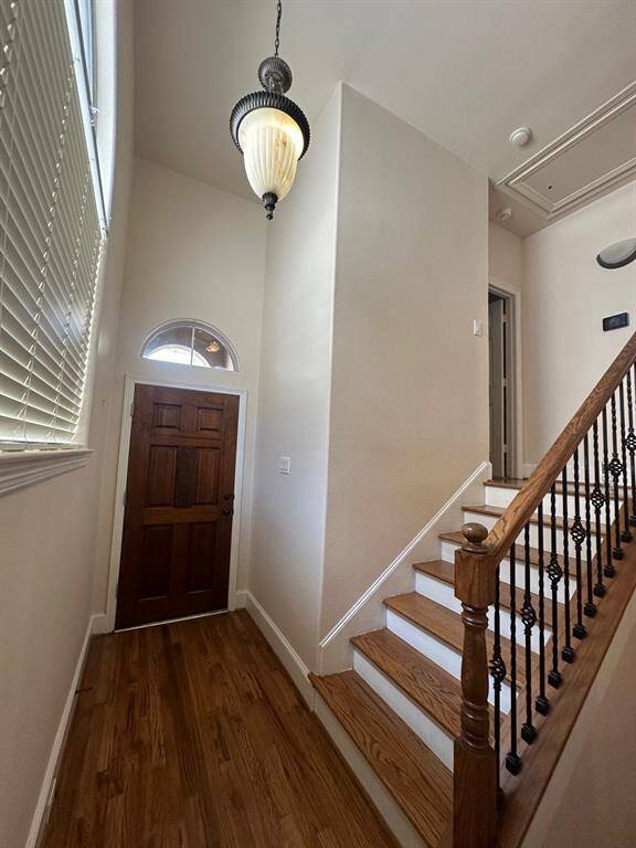 Engry with high ceilings and wood flooring
