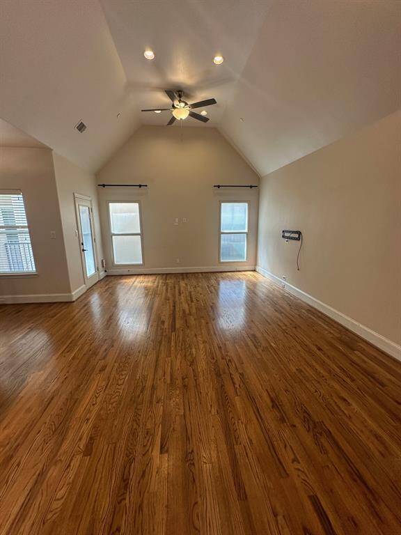 Large living area with high ceilings, recessed lighting and hardwood flooring