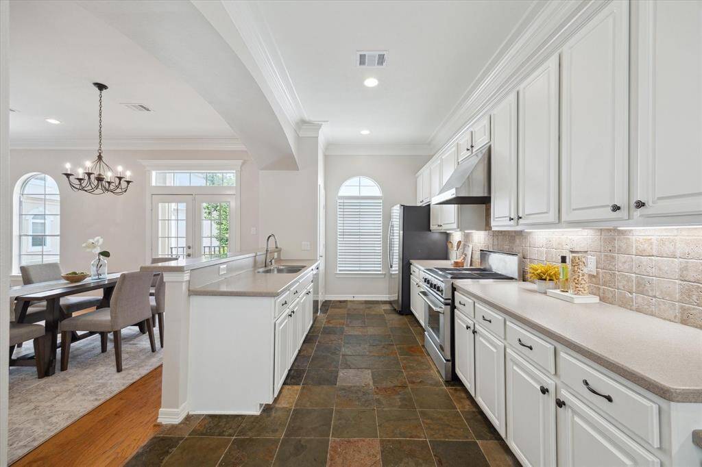 Large kitchen has a commercial grade gas range, stainless steel appliances, lots of counter space, and bar seating.
