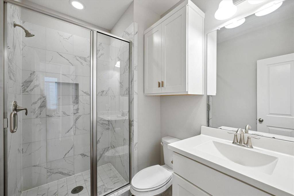 The full bathroom on the second floor showcases an upgraded walk-in shower with sleek finishes—adding a touch of luxury and convenience for guests or residents alike.