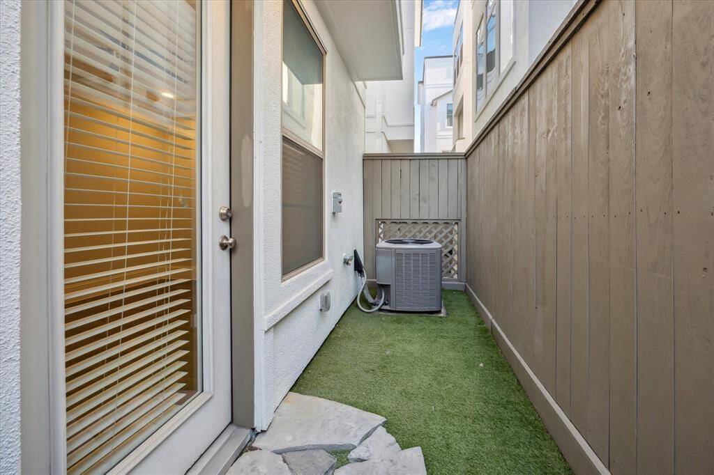 Enjoy the low-maintenance side patio featuring a turfed yard and stone step-out—perfect for pets, outdoor dining, or a little fresh air without the upkeep.