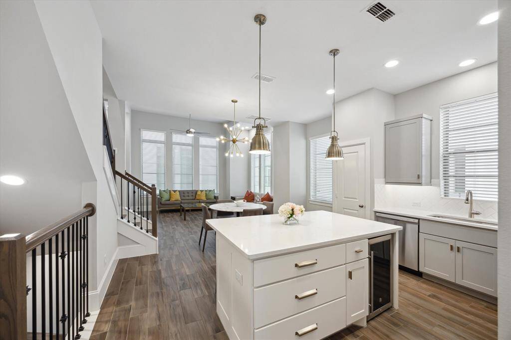 The spacious second-floor dining area flows effortlessly into the kitchen, where a generous island with seating invites casual meals and conversation. Sleek finishes and thoughtful design make this space both functional and stylish. Just off the main living area, a staircase leads to the private third-floor retreat, offering a quiet and comfortable escape in the primary bedroom suite.