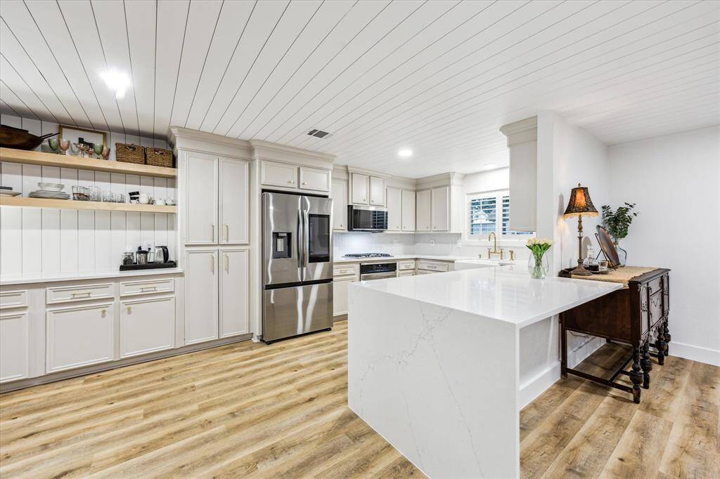Polished Valor Gold Quartz countertops in Kitchen with waterfall island