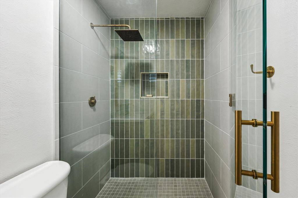 Fixed panel ½” frameless glass w/ curb less “walk-in” shower at Master Bath with new Hardie backer, pan liner, & PEX plumbing. New tile with accent shower wall & Schluter shower niche.