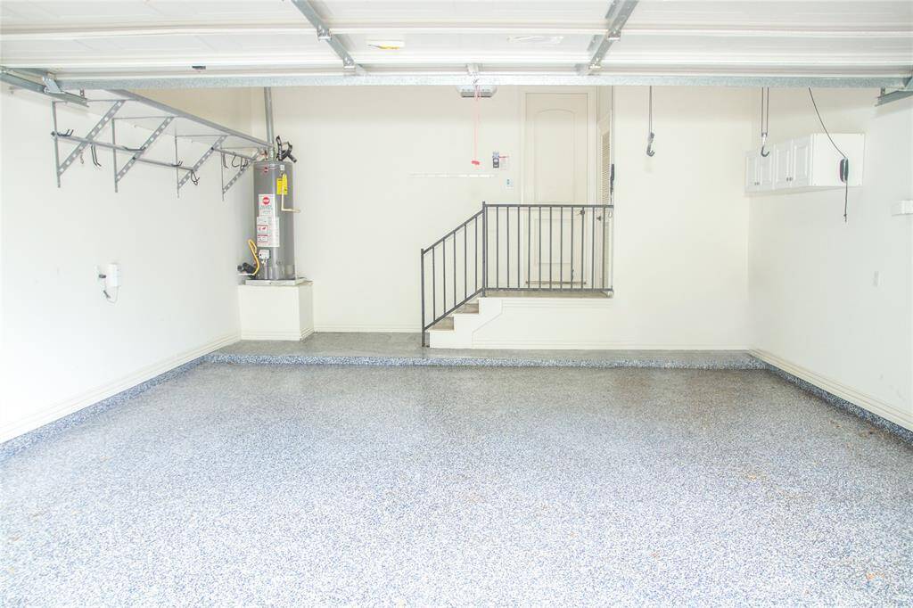 2 car garage w/ built in cabinets, shelves, and has a storage closet