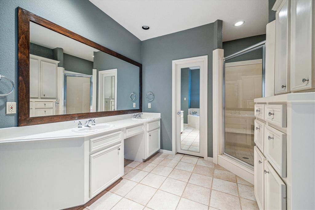 Primary Bath – 12 x 9:  Features separate walk-in shower, soaking tub and private water closet.  Double vanities, wall length wood framed vanity mirror and built-in above and below storage cabinets with additional drawer storage.
