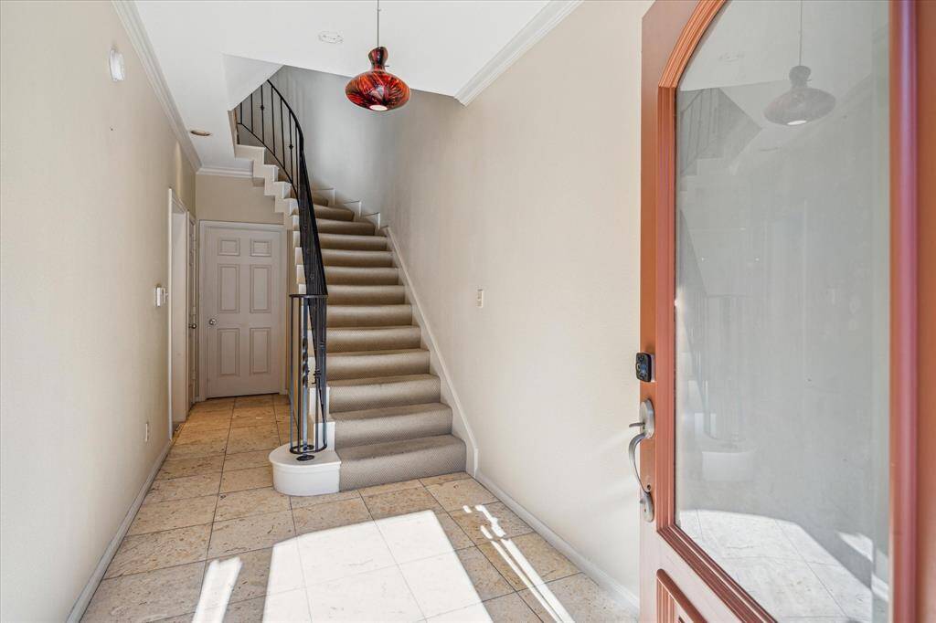 Another look at the spacious entry featuring the solid wood door with sidelights, transom, travertine flooring and decorative chandelier.