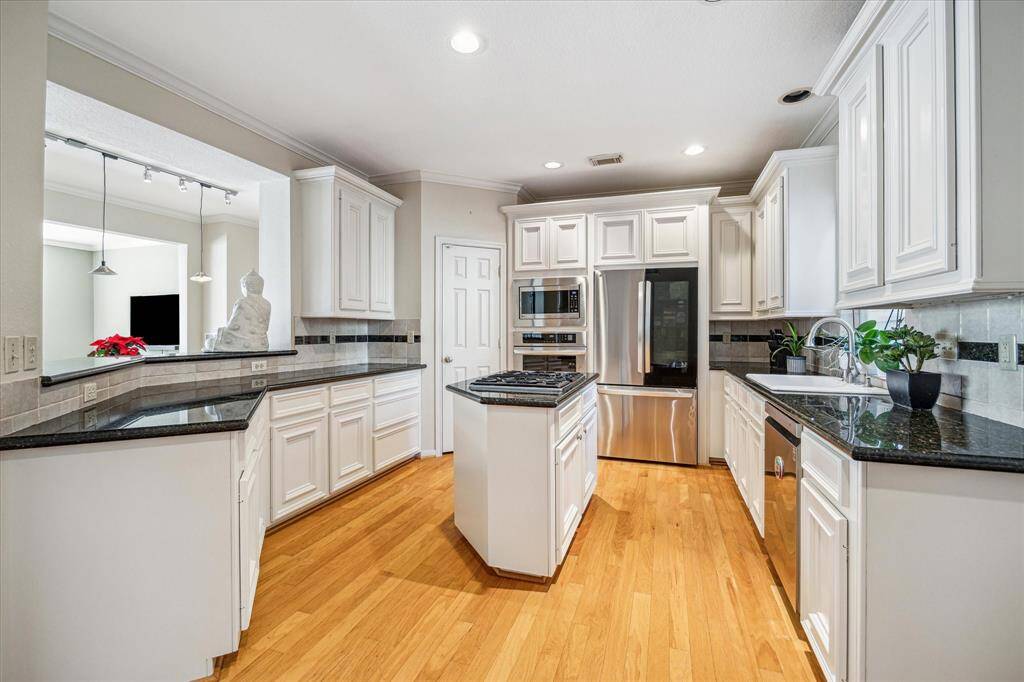 Kitchen - 13 x 10:  The gourmet kitchen has granite counters, an island, breakfast bar, ample storage, and new stainless steel appliances (2023).  Bar height open pass through can be utilized as a serving station.