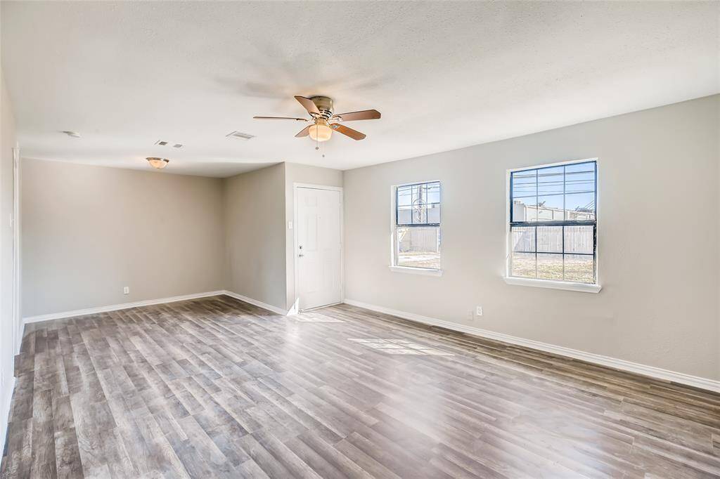 View of the living room looking towards the front door and dining room. Windows look out to the front yard.