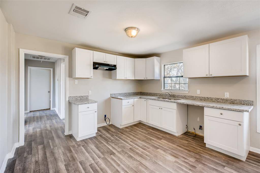 Alternate view of the kitchen. Hallway on the left leads to 2 bedrooms and a full bathroom.