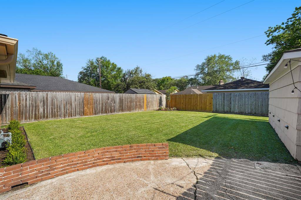 Large back yard with lush grass and new landscaping.
