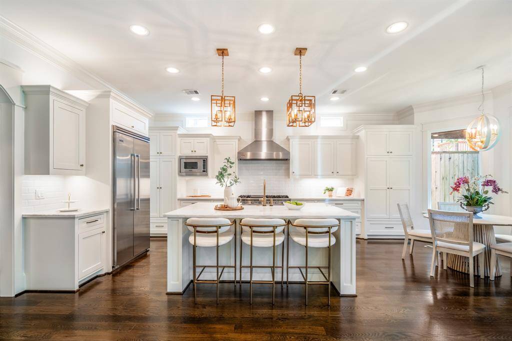Clean lines and warm finishes define this family-focused kitchen, where generous storage and integrated seating effortlessly support daily routines and festive celebrations alike.