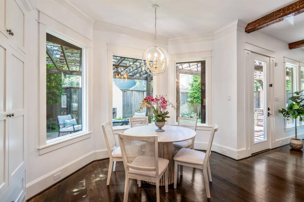 The intimate breakfast area is a serene spot to start the day, offering a front-row view of the beautifully designed backyard through floor-to-ceiling windows.