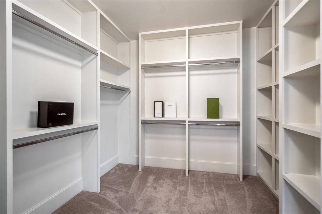 A boutique-inspired walk-in closet offers custom storage from floor to ceiling, designed to showcase your wardrobe while keeping everything beautifully organized.