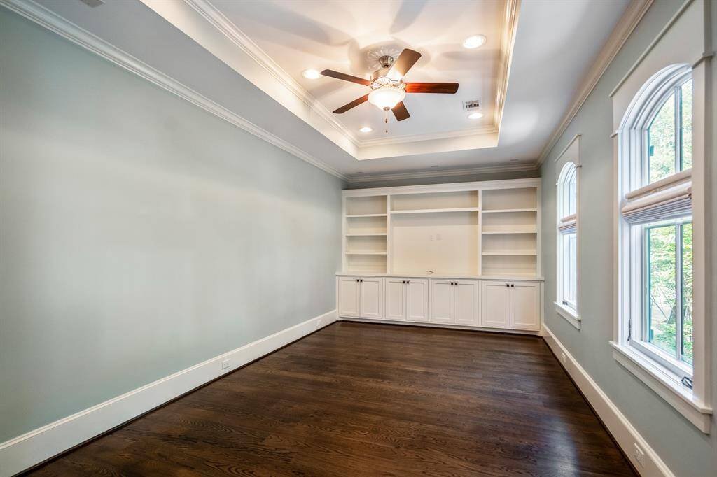 This upstairs game room offers plenty of space and flexibility for everyday living. Built-in cabinets and open shelves help keep things organized, while the tray ceiling, soft-toned walls, and white oak hardwood floors add warmth and charm. Perfect as a media room, play area, reading nook, or home gym - it's ready to fit your family’s needs!