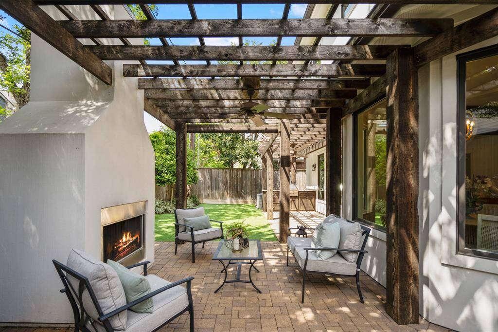 The patio is anchored by a modern stucco fireplace and surrounded by ample space for lounging, making it the perfect extension of the indoor living space.