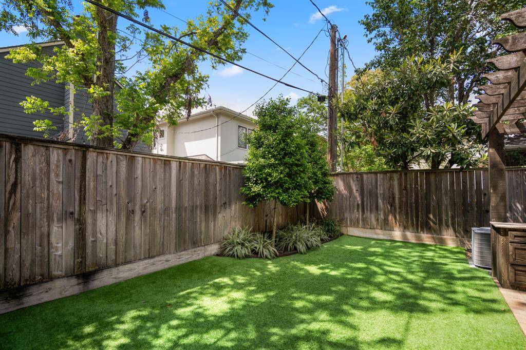 A full view of the backyard reveals a seamless indoor-outdoor connection, with space for grilling, entertaining, or simply relaxing under the canopy of trees. This home truly checks all the boxes!