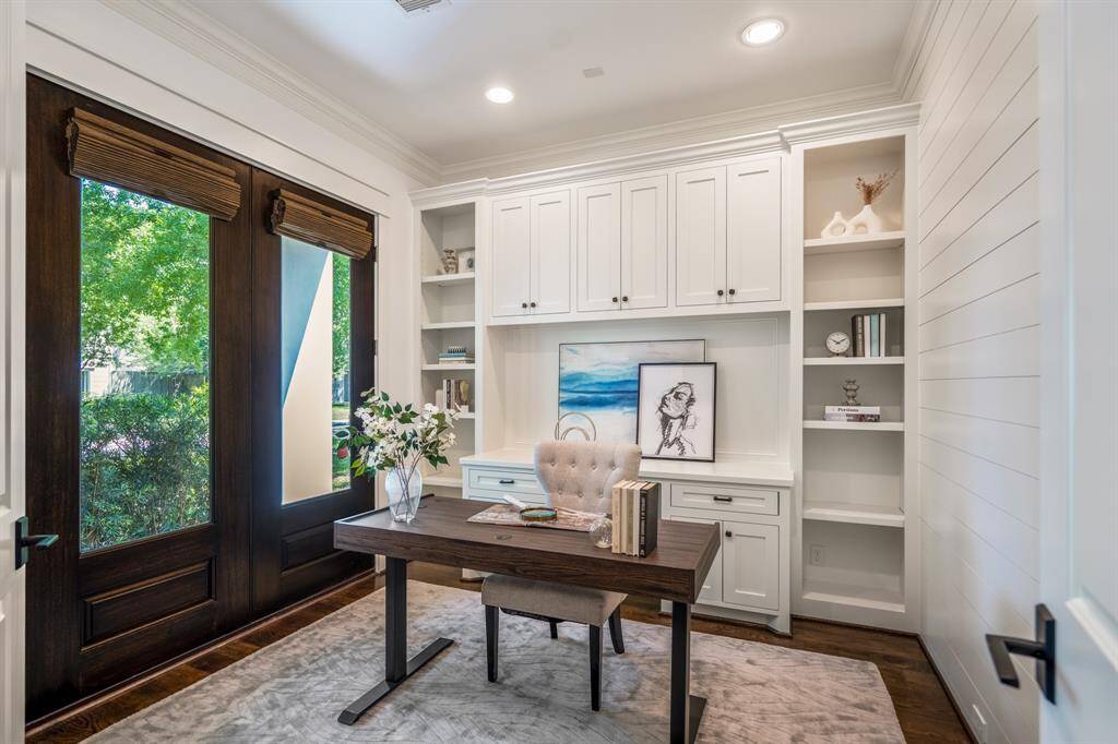 Custom built-ins, crisp shiplap paneling, and tall ceilings give this home office a refined presence, ideal for remote work, creative pursuits, or quiet study time.