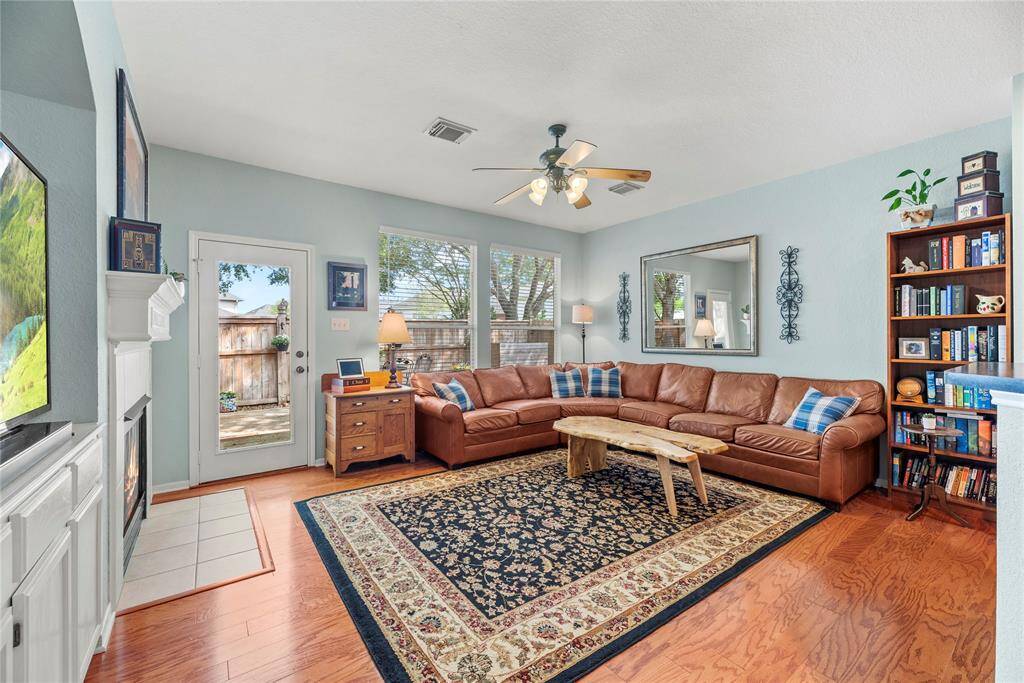 Living room featuring beautiful hardwood floors and multiple windows that flood the space with natural light, creating a warm and inviting atmosphere.