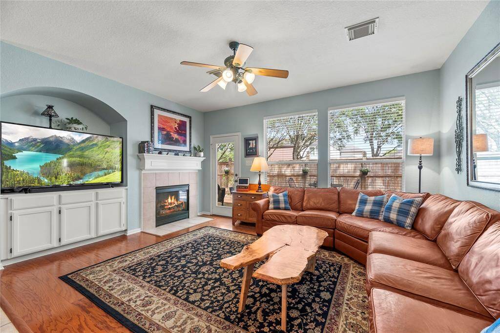 This living room also features a warm fireplace and ceiling fan.