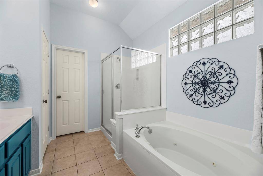 Alternate view of the bathroom featuring the glass-enclosed shower and separate tub.