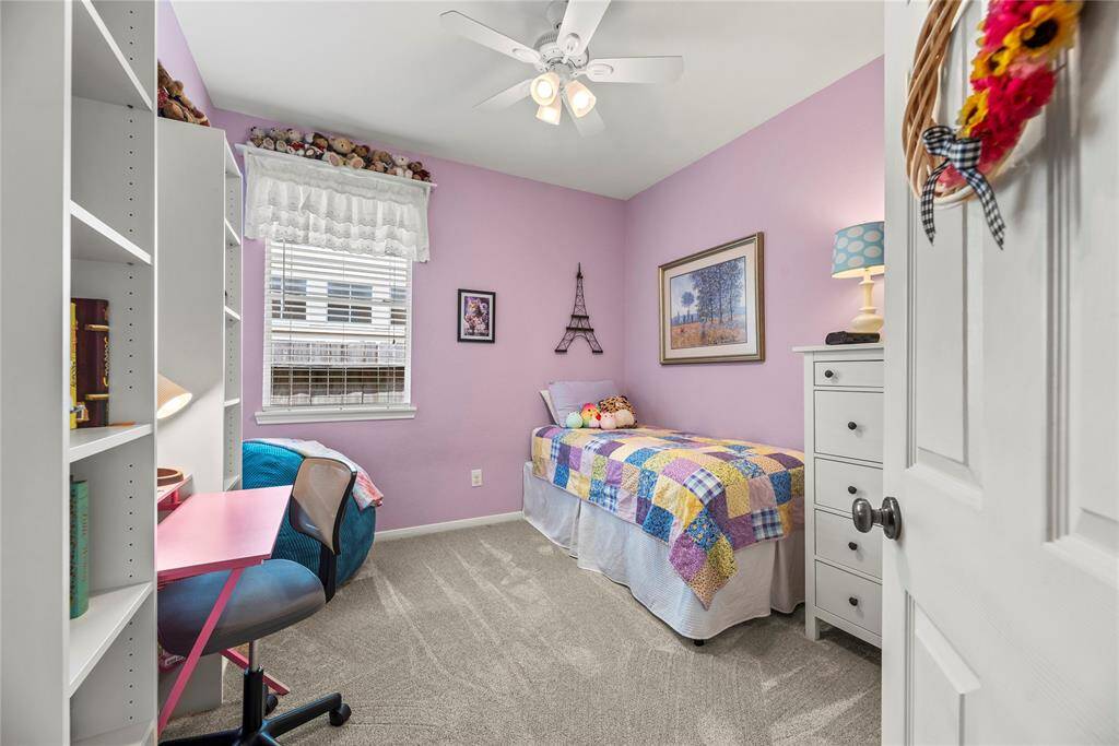 Second bedroom featuring carpet flooring and ceiling fan.