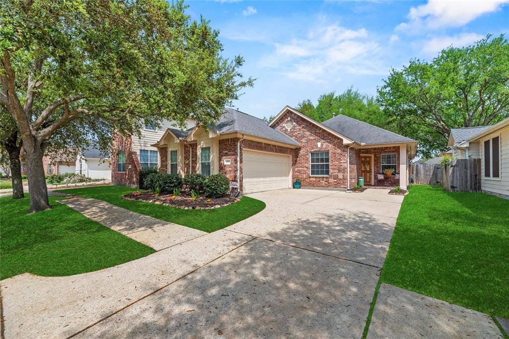 Charming home features a welcoming front yard with mature trees and well-maintained landscaping. It includes a spacious driveway leading to a two-car garage, and the exterior offers a blend of brick and siding for a classic look.