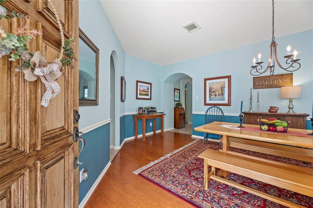 This inviting entryway features a charming wooden door, leading to the dining area.