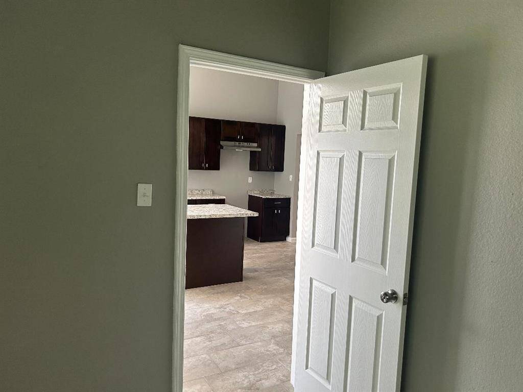 Master bedroom view shows a glimpse into the kitchen.