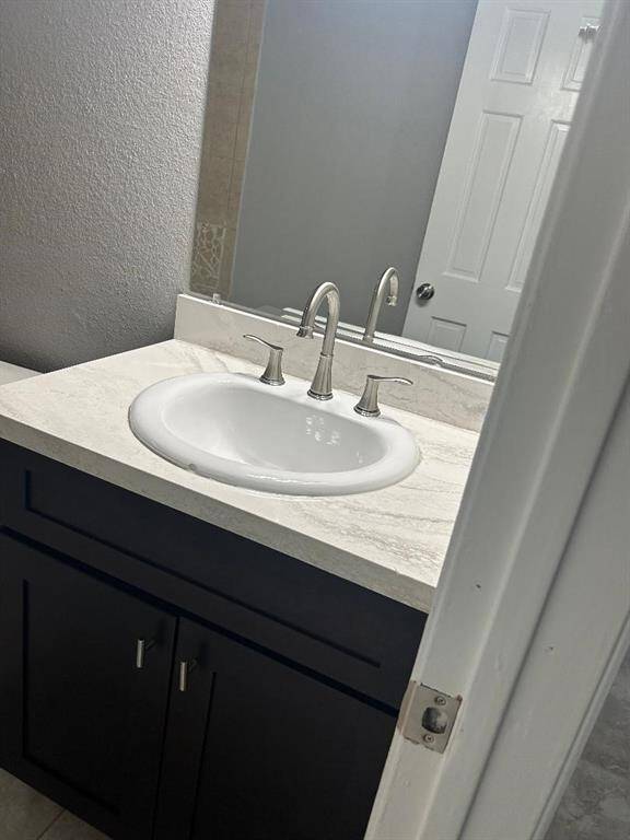Hall bathroom shows a modern bathroom sink with a sleek faucet, set in a marble countertop atop a dark cabinet, providing a clean and contemporary look.