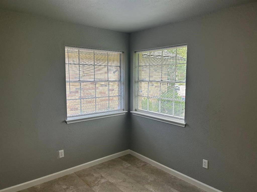 Cozy corner front bedroom with two large windows providing ample natural light and front outside view.