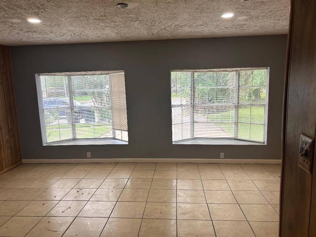 Large front bedroom with two large bay windows and view of the front driveway and lawn. Bedroom has window AC unit NOT central AC.