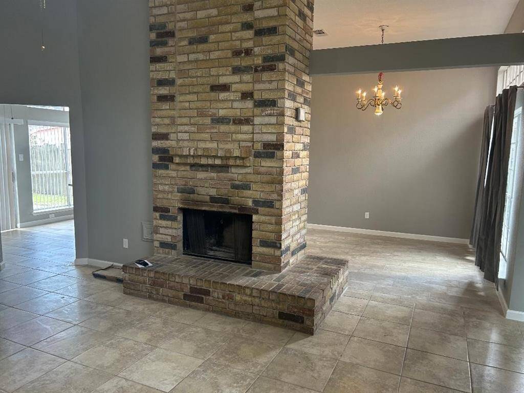 View from living area which features a central brick fireplace, provides ample natural light, and the open layout offers versatile space for living and dining areas.