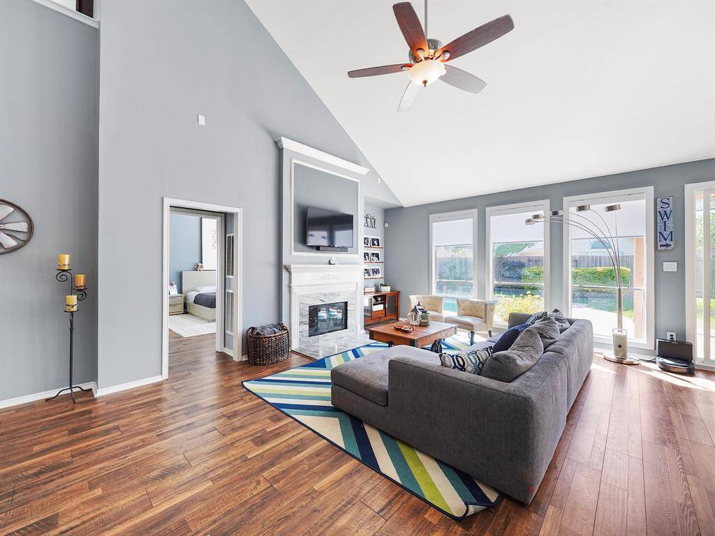 A wall of windows floods the area with natural light, accentuating the beautiful fireplace that serves as a focal point in the living room.